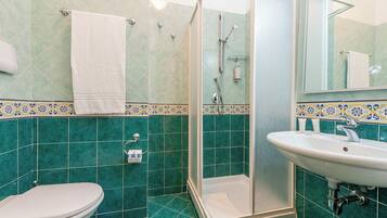 A bathroom with a shower, toilet, and sink.