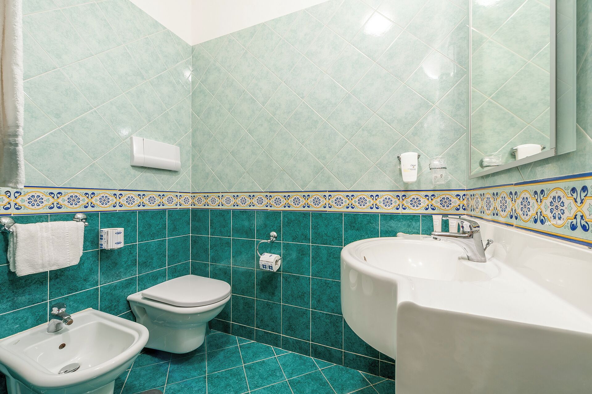 A bathroom with a toilet, bidet, and sink.