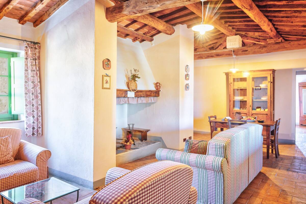 A cozy living area with checkered sofas, a glass coffee table, and a wooden ceiling.