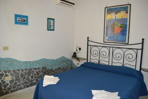 Un dormitorio con una cama, una mesita de noche y un cartel en la pared.