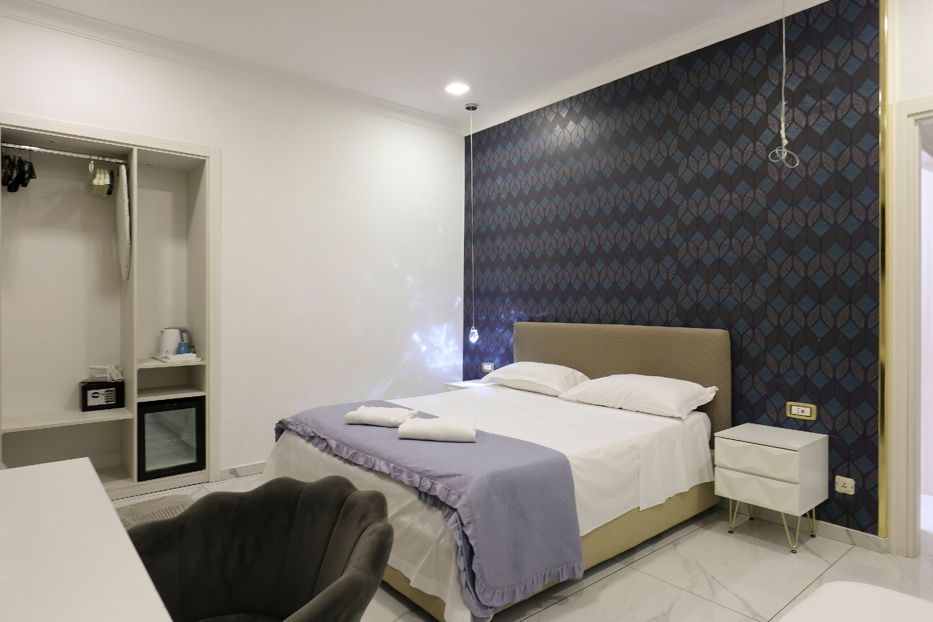 A bedroom with a bed, bedside table, and a wardrobe.