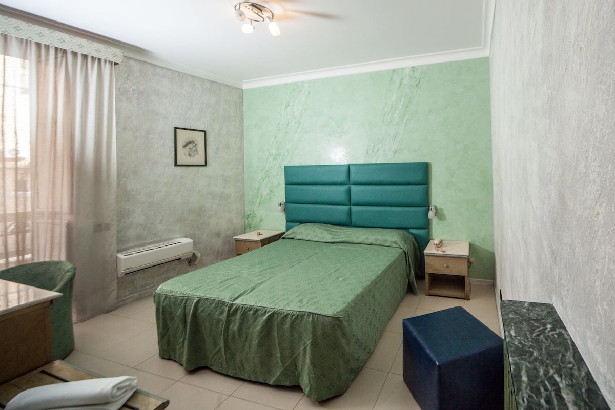 Una camera da letto con un letto, comodini, una scrivania e una sedia.