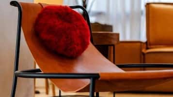 Un espace de détente moderne avec un banc en bois et un coussin rouge moelleux.