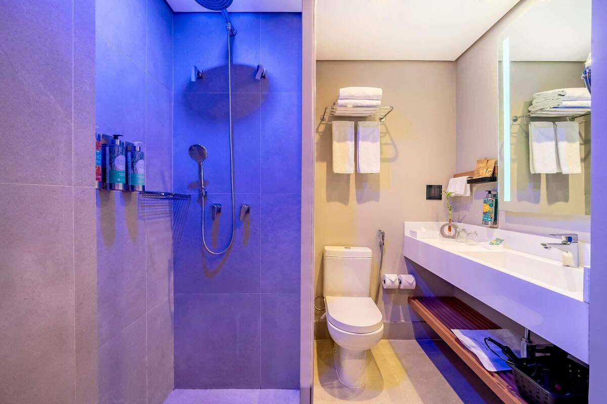 Et moderne badeværelse med brusebad, toilet og vask.
