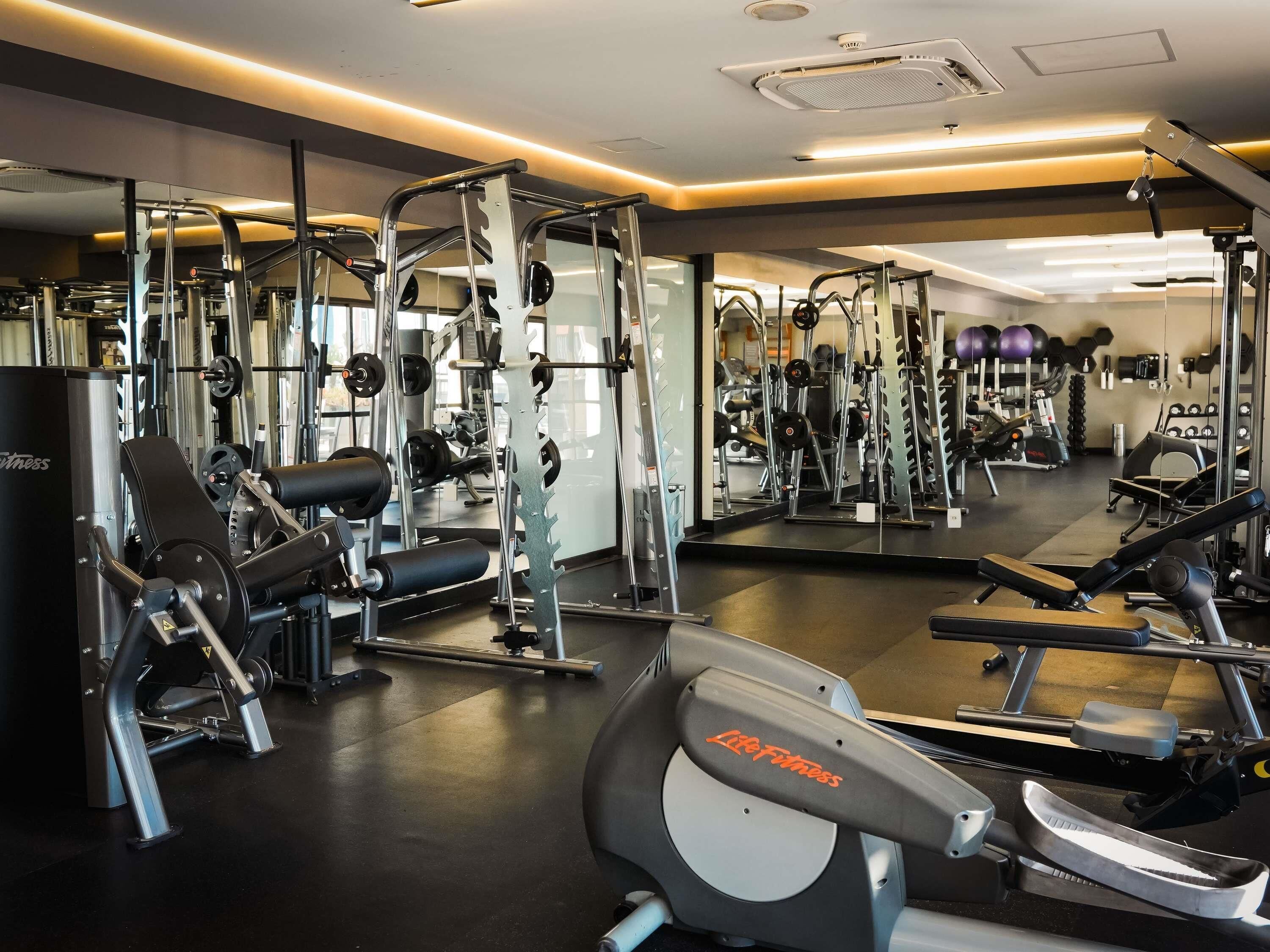 A gym with various exercise equipment, including treadmills and weight machines.