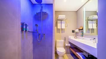 Un baño moderno con ducha, inodoro y lavamanos.