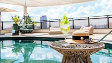 Una piscina al aire libre, sillones reclinables de piscina