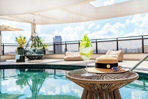 Una piscina al aire libre, sillones reclinables de piscina