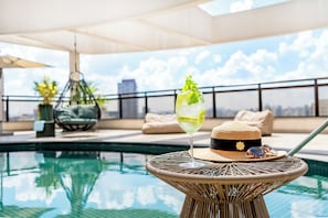 Una piscina al aire libre, sillones reclinables de piscina