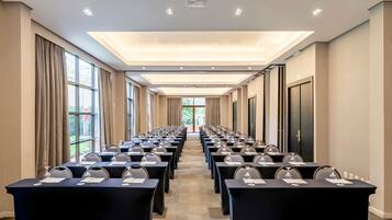A conference room with rows of tables, a projector, and large windows.