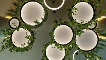 A ceiling with circular light fixtures surrounded by greenery.