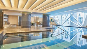 A modern indoor swimming pool with clear glass walls, a tiled floor, and a contemporary ceiling design. - The Westin Bund Center, Shanghai (Shanghai)