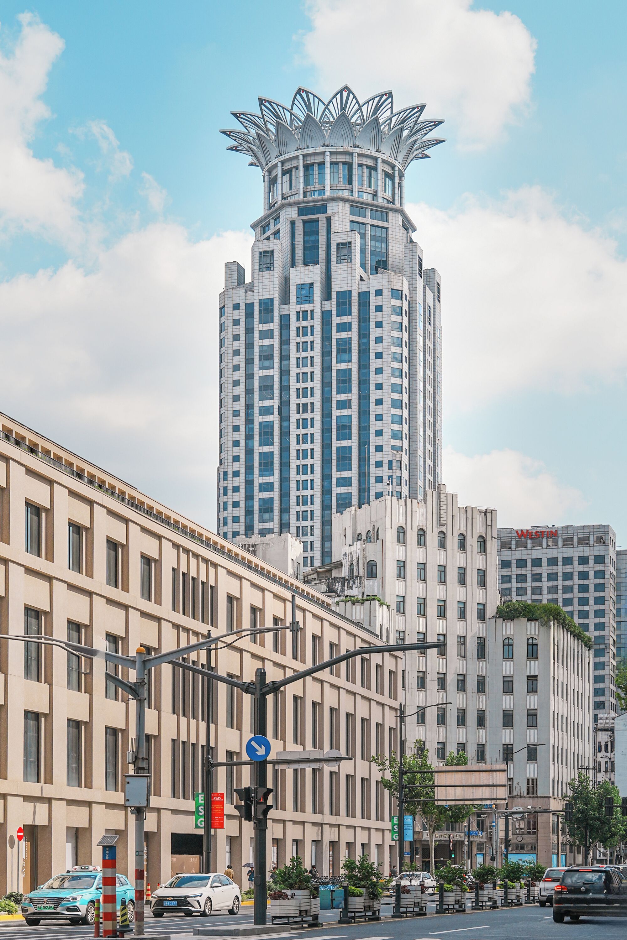 A modern high-rise building with a unique architectural design, featuring a tiered structure and a central spire.