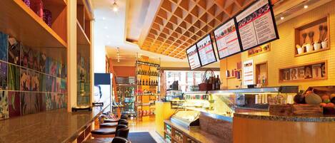 A restaurant interior with a bar area, seating, and a menu display.