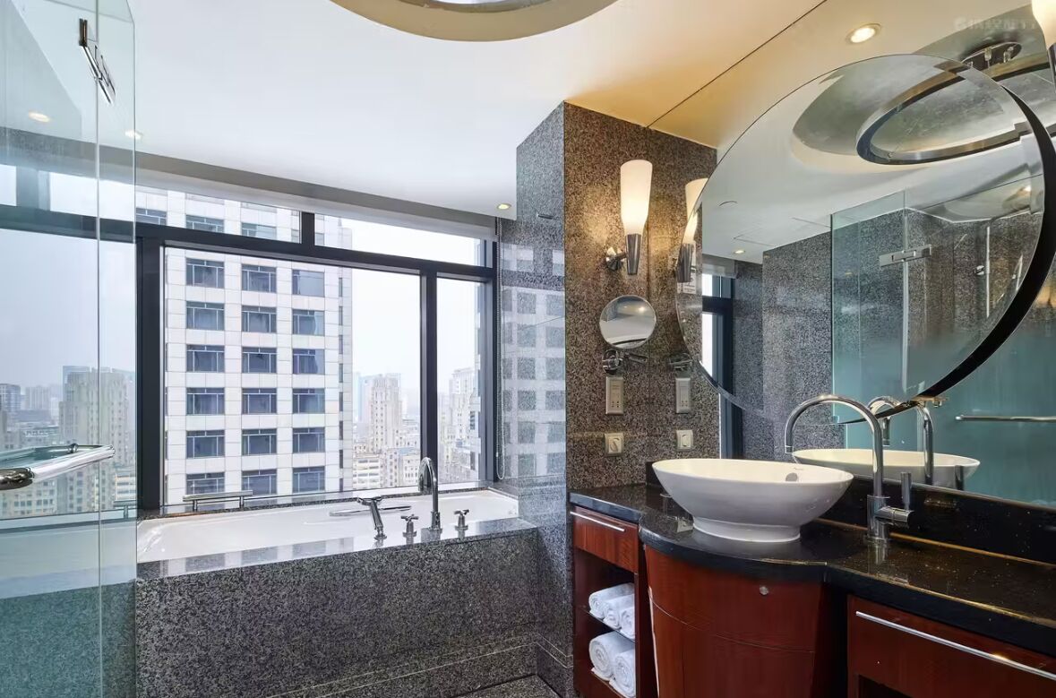 Une salle de bain moderne avec une grande fenêtre, un double vasque et un miroir.