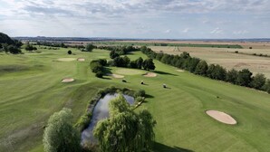 Un campo de golf con varios bunkers y un estanque.