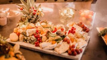 Een schaal met verschillende kazen en fruit op een tafel.