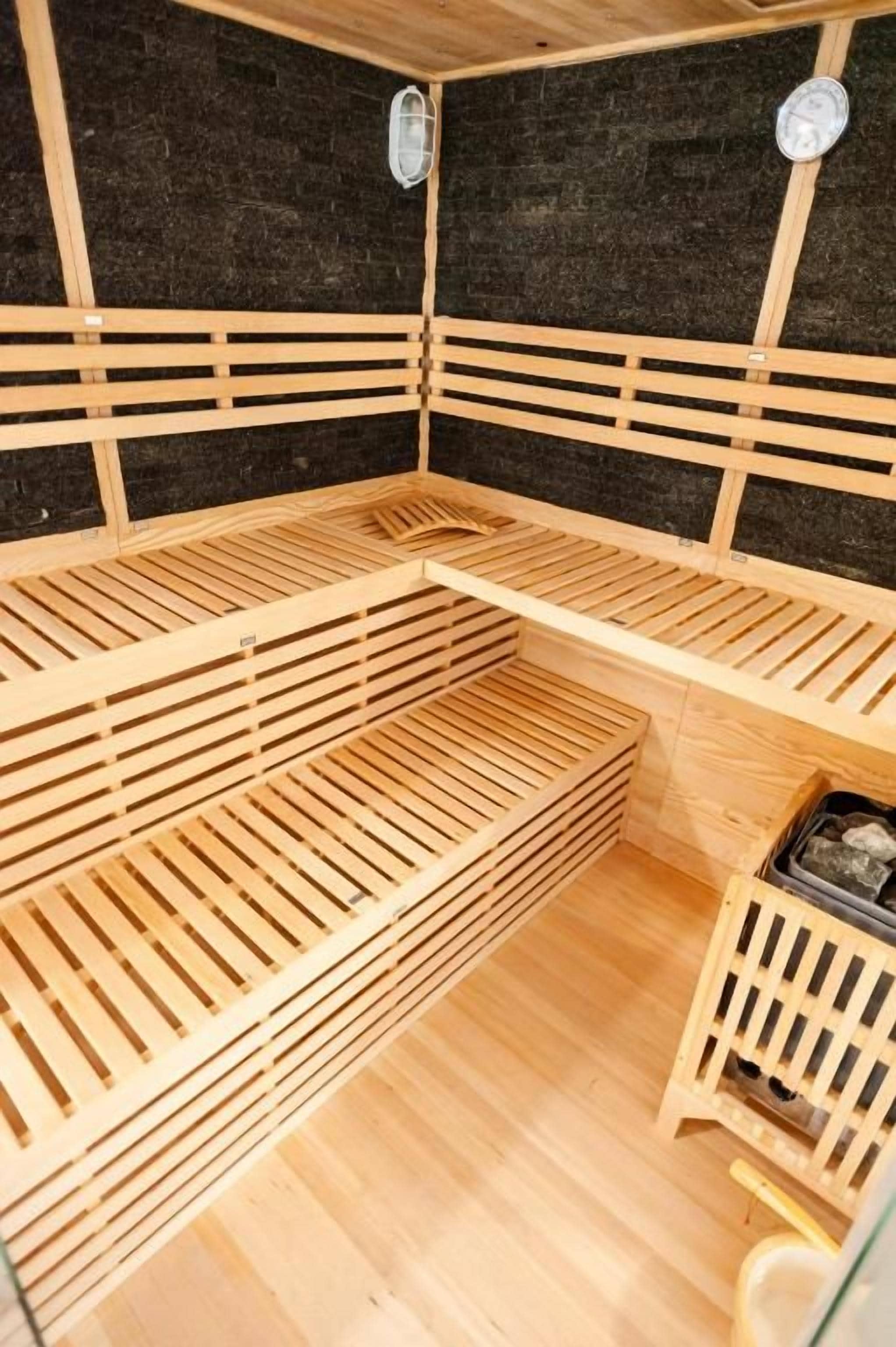 Una sauna con bancos de madera y un banco con respaldo.