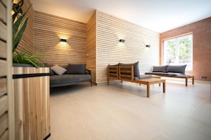 Un salon moderne avec un canapé, une table basse en bois et un banc.