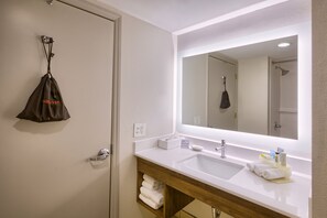 A bathroom with a white sink, a mirror, and a towel rack.