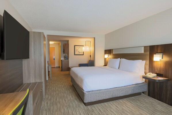 A hotel room with a large bed, bedside tables, a flat-screen TV, and a desk with a chair. - Holiday Inn Express & Suites Raleigh North - Wake Forest by IHG (Raleigh)