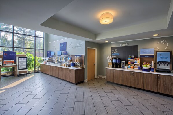A modern breakfast area with a self-serve station, a coffee machine, and a fruit display. - Holiday Inn Express & Suites Raleigh North - Wake Forest by IHG (Raleigh)