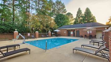 Una piscina al aire libre de temporada, sombrillas