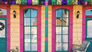 A colorful building with large windows and a swing chair outside.