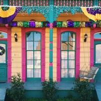 A colorful building with large windows and a swing chair outside.