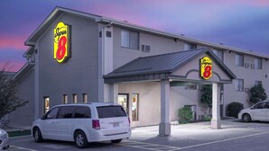 Un hotel Super 8 con un estacionamiento y una camioneta blanca estacionada al frente.