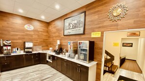 A breakfast area with a wooden wall, a clock, and a coffee machine. - Super 8 by Wyndham Winona MN (Winona)