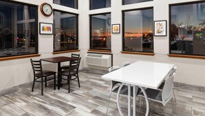 A hotel room with large windows, a clock, and framed pictures on the walls. - Super 8 by Wyndham Winona MN (Winona)