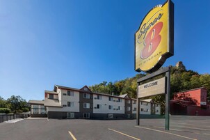 Un hotel con un letrero grande que dice 'Super 8 by Wyndham' y un cartel de bienvenida.