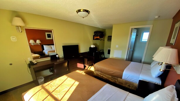 A hotel room with two beds, a desk, a chair, a television, and a mirror. - Best Stay Inn - Manchester (Manchester)