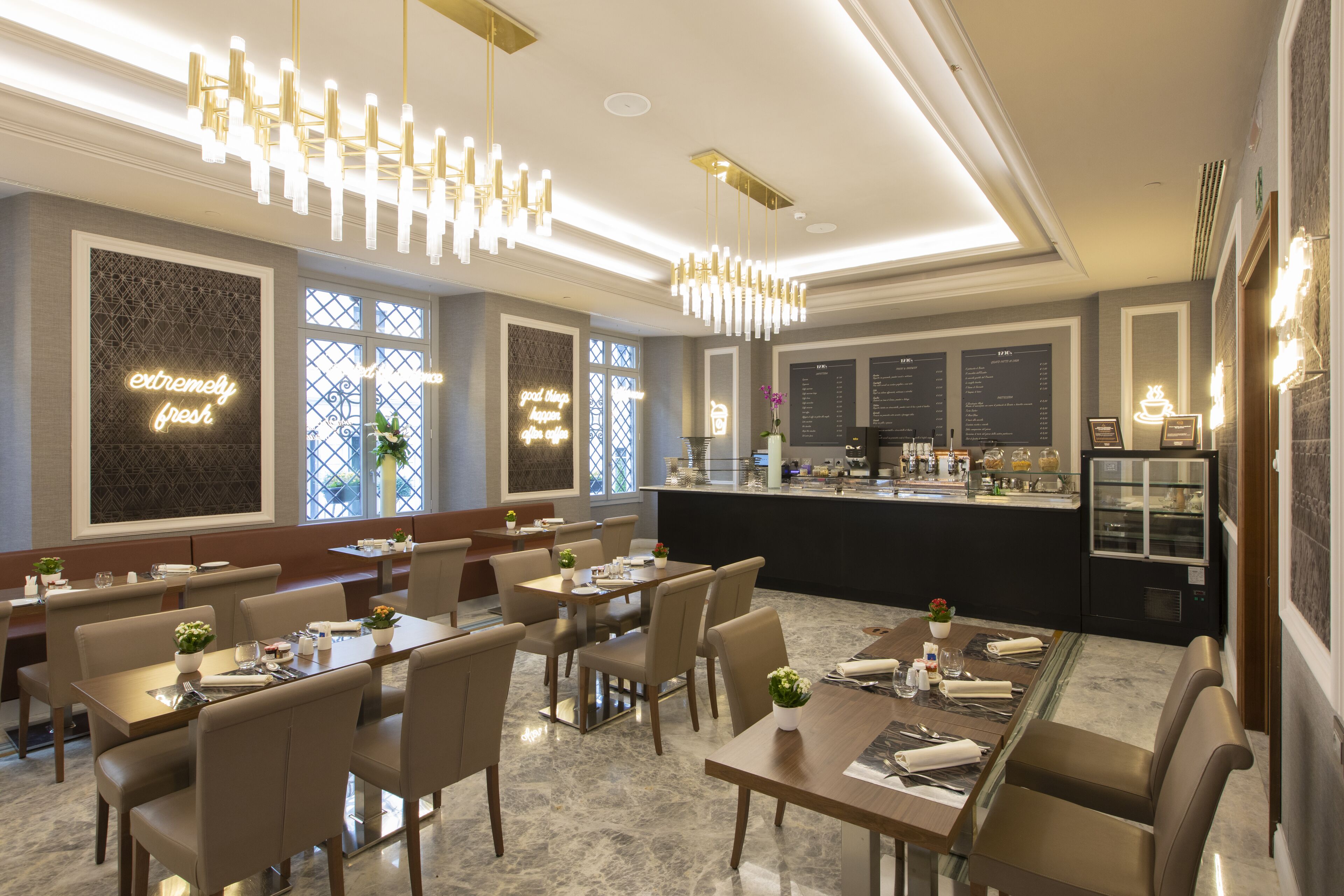 A modern restaurant with a bar area, dining tables, and chairs.