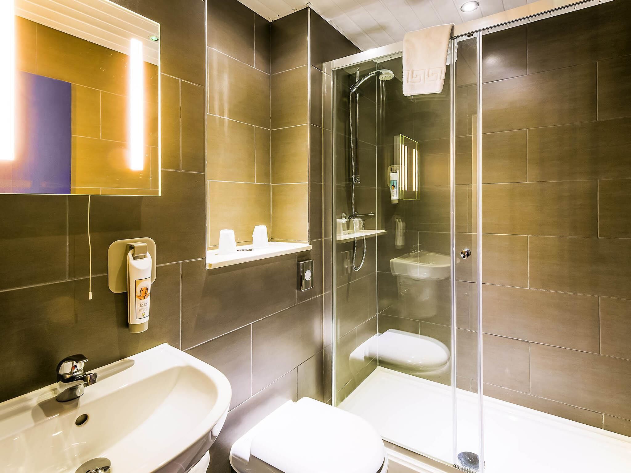 A modern bathroom with a glass-enclosed shower, a sink, and a toilet.