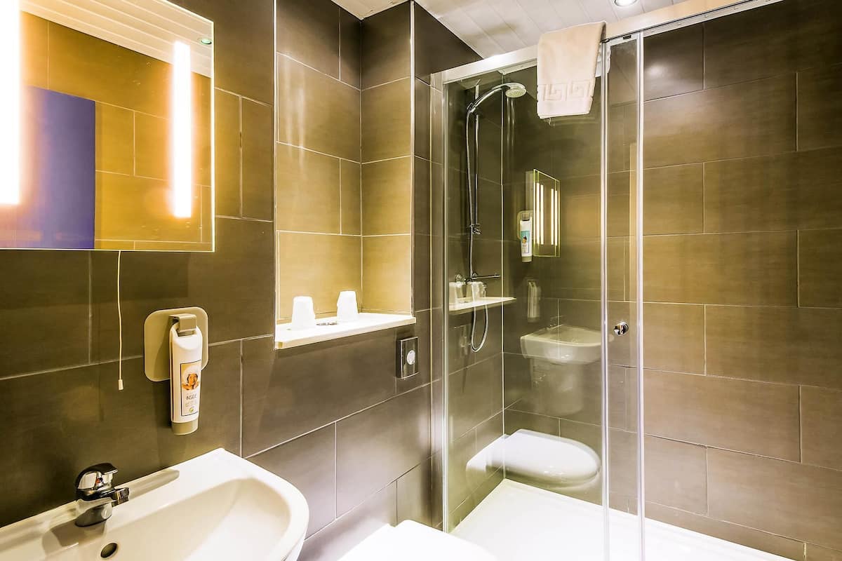 Ein modernes Badezimmer mit einer Duschkabine, einem Waschbecken und einer Toilette.