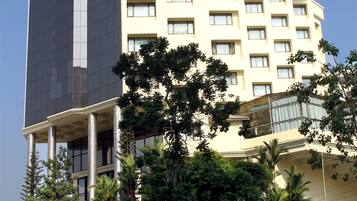 A multi-story hotel with a modern design, featuring a prominent glass facade and a flat roof.