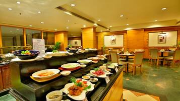 A buffet area with various dishes and a sign listing salad options.