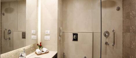 Un baño moderno con un espejo grande, un lavabo, un inodoro y una zona de ducha.