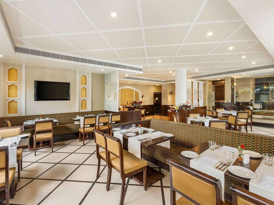 A spacious restaurant with high ceilings, multiple dining areas, and a modern design.