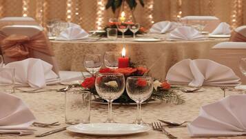 Una mesa dispuesta para un evento formal, con un centro de mesa, velas y copas.
