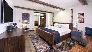 A hotel room with a large bed, a desk, a TV, and a view of the city. - El Cortez Hotel and Casino - 21 and Over (Las Vegas)