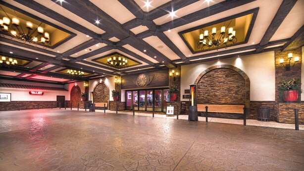 A spacious lobby with a stone floor, wooden beams, and a large chandelier. - El Cortez Hotel and Casino - 21 and Over (Las Vegas)