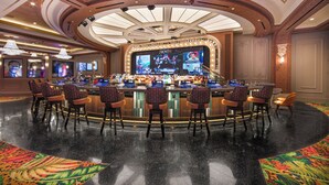 A bar area with multiple screens, bar stools, and a central bar counter. - El Cortez Hotel and Casino - 21 and Over (Las Vegas)