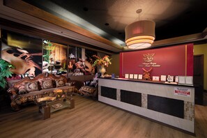 A reception area with a wooden reception desk, a sofa, and a wall with posters.