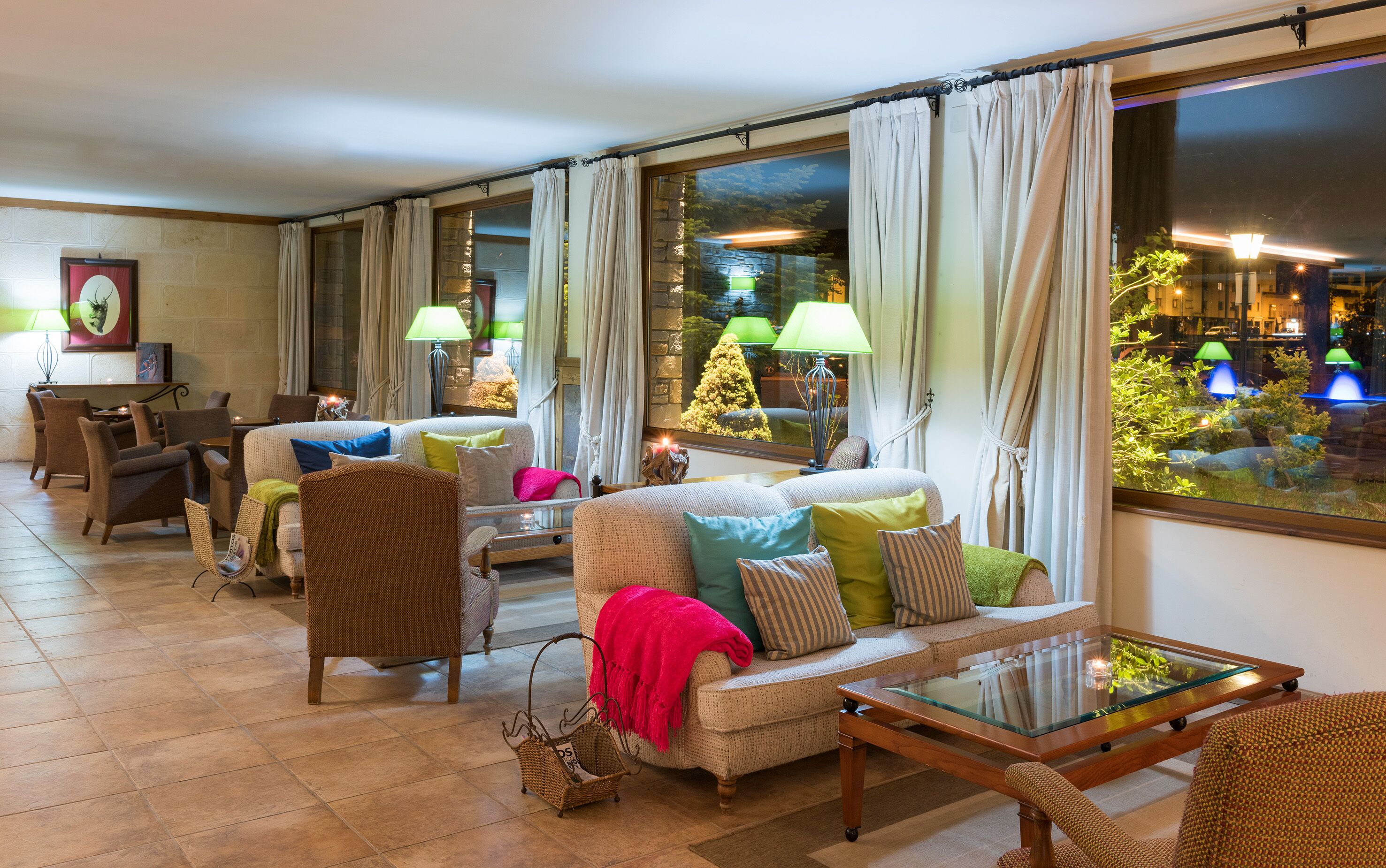 A cozy living room with a sofa, armchairs, and a glass coffee table.