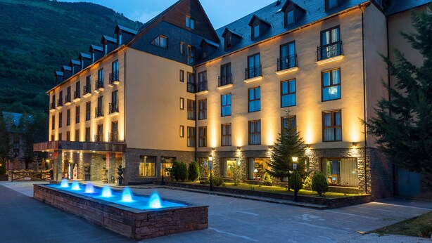 A multi-story hotel with a courtyard, outdoor lighting, and a fountain. - Hotel Vielha Val d'Arán, Affiliated by Meliá (Vielha e Mijaran)