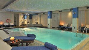 A swimming pool with lounge chairs and a lifebuoy on the wall. - Hotel Vielha Val d'Arán, Affiliated by Meliá (Vielha e Mijaran)