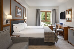 A hotel room with a large bed, a desk, a chair, a television, and a window with curtains. - Hotel Vielha Val d'Arán, Affiliated by Meliá (Vielha e Mijaran)